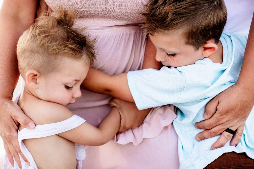 Close up of two toddler boys hugging their mom and dad