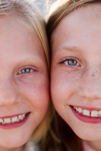 Close up of two girls faces temple to temple