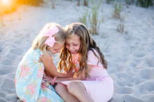 Two young girls tickling each other on the beach in Ocean City New Jersey