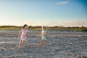 Sisters running on the beach at sunset in Ocean City New Jersey