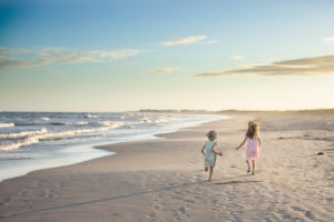 Sisters running away from the camera on the beach at sunset in Ocean City New Jersey