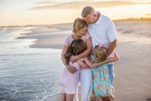 Family hugging on the beach by the ocean in Ocean City New Jersey