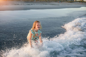 young girl jumping in the ocean waves