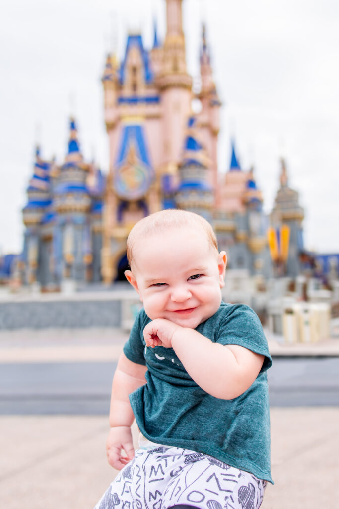 Baby sitting in from of Cinderella's castle at Magic Kingdom in Walt Disney World Florida